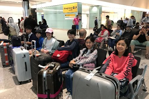 笑顔の留学生。空港の椅子に座っている