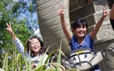 サマーキャンプ遠足でジェットコースターに乗る学生たち